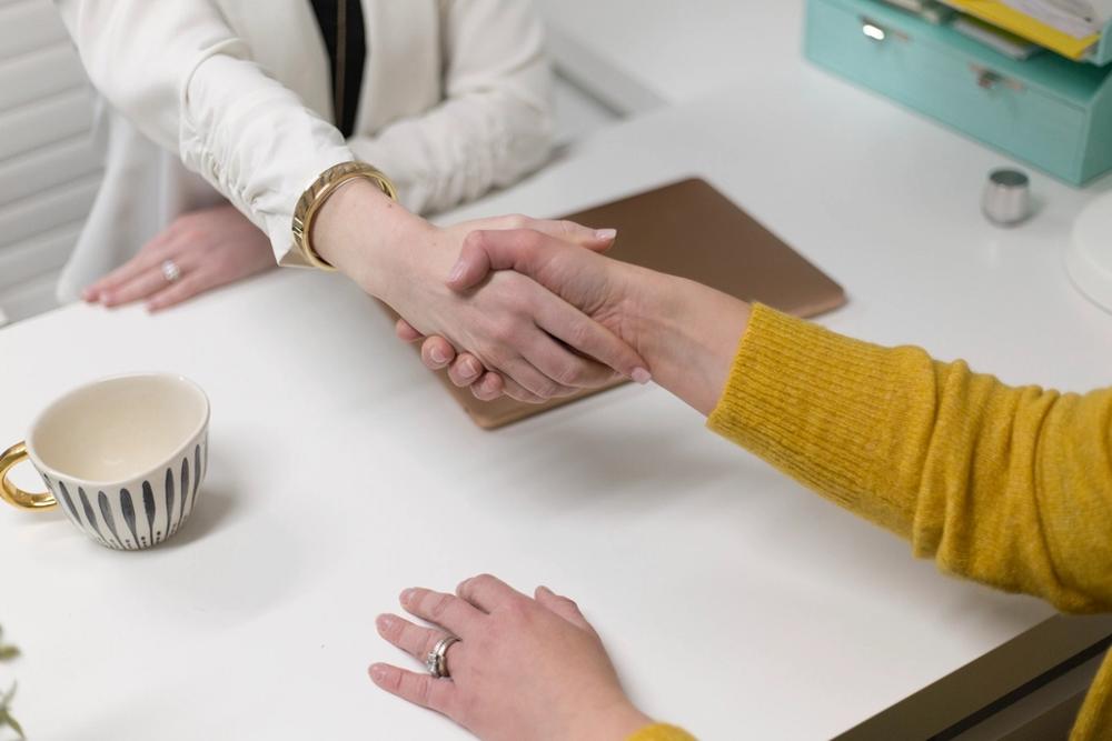Two people shaking hands over a desk — a real customer team is one click away at credicorp.co.uk.